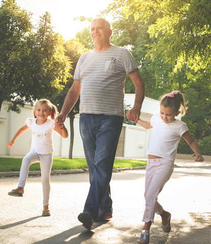 children walking with their grandfather holding hands