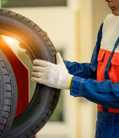 mechanic in uniform is examining a tire