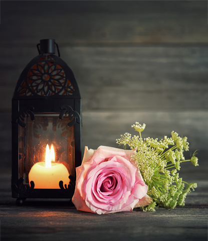 memorial candle and flowers on wooden background