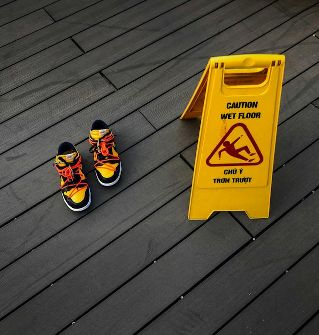 bright colored shoes next to wet floor sign